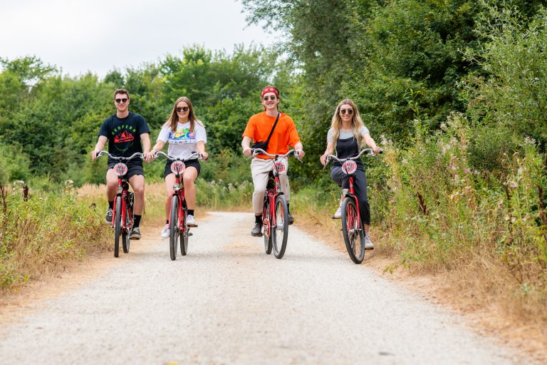 Vier fietsers in kleurrijke outfits die door het Schinkelbos fietsen
